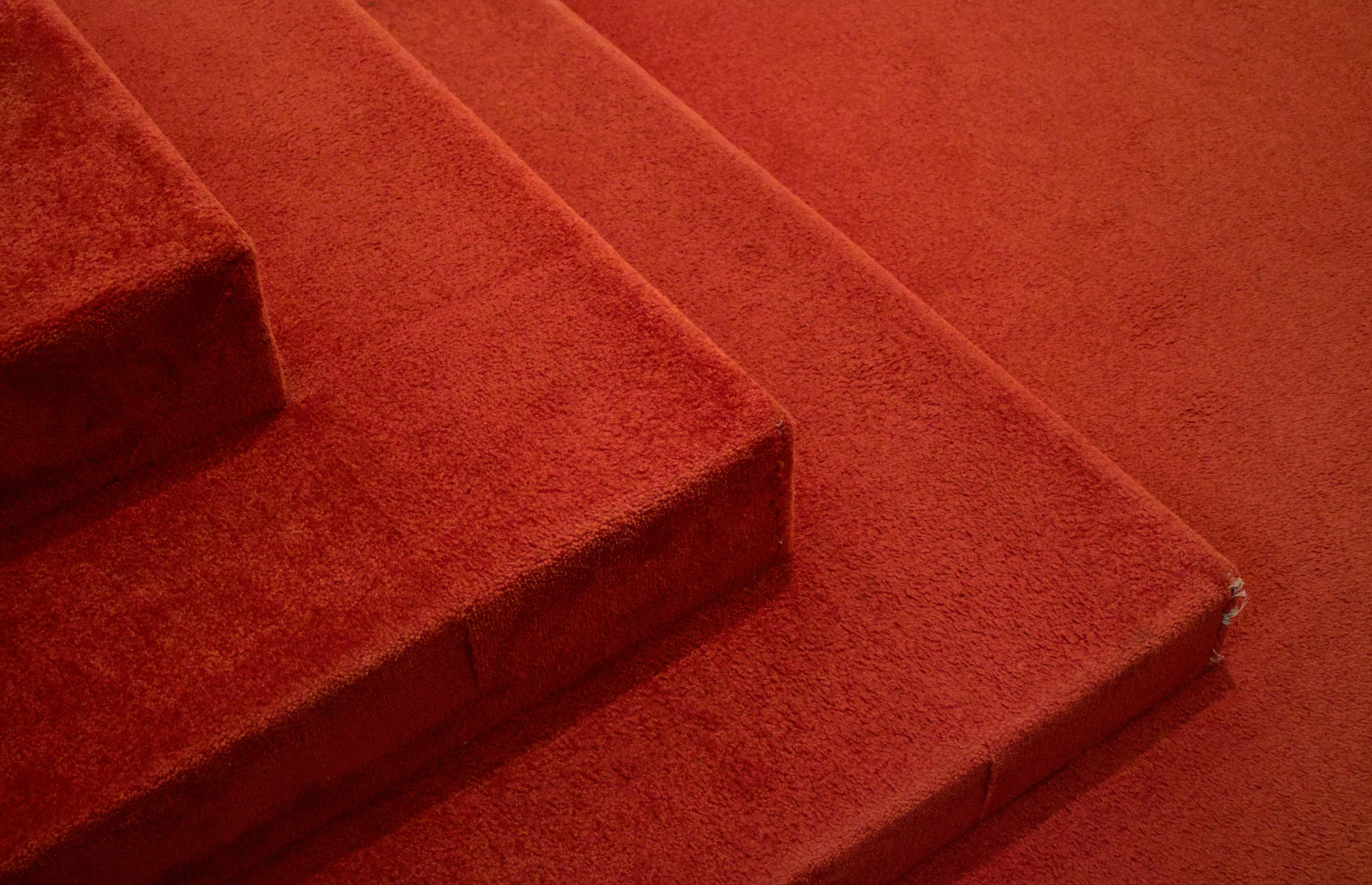 Red carpeted stairs with wear